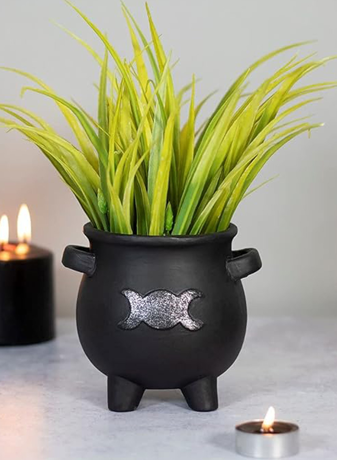Goddess Cauldron Planter Pot – svart gotisk blomkruka i form av en häxkittel med silverfärgad trippelmåne, små handtag och gröna växter.